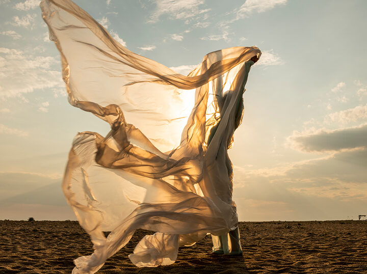 Woman on beach with fabric
