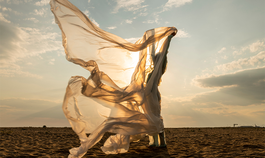 Woman on beach with fabric