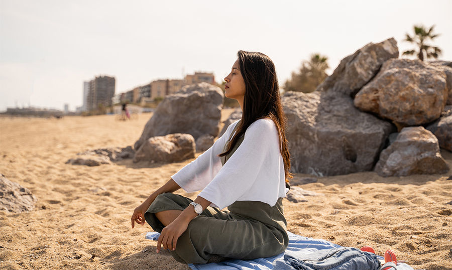 Woman siting on the sand meditating