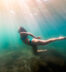 Woman in bikini diving exploring shallow blue green waters of Lake Ontario