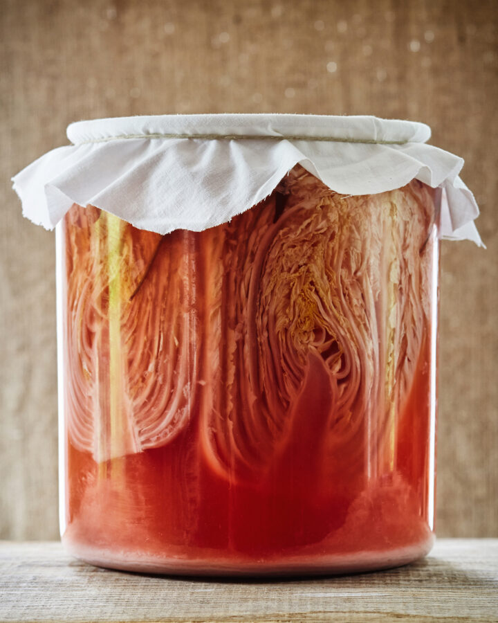 Fermented cabbage/ sauerkraut in glass jar on wood surface